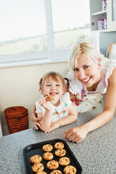 Smiling girl eating cookie — Stock Photo, Image