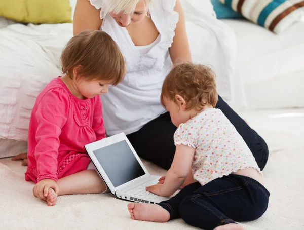 Woman working with her children at laptop — Stock Photo, Image