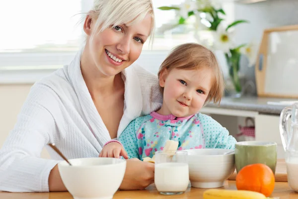 Mãe e filha radiante tomando café da manhã — Fotografia de Stock