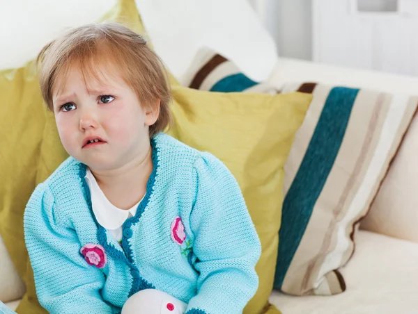 Small girl crying on sofa — Stock Photo, Image