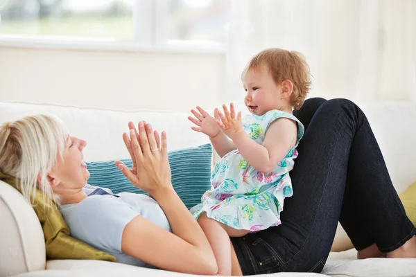 Mãe atraente brincando com sua filha — Fotografia de Stock