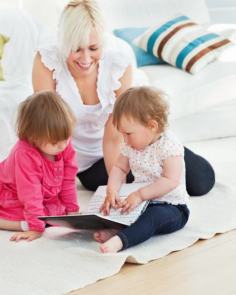 Pretty woman working with her children at laptop — Stock Photo, Image