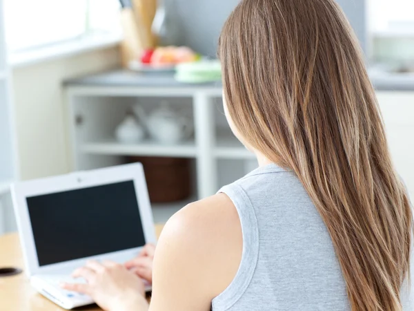 Привлекательная женщина сидит перед своим ноутбуком — стоковое фото