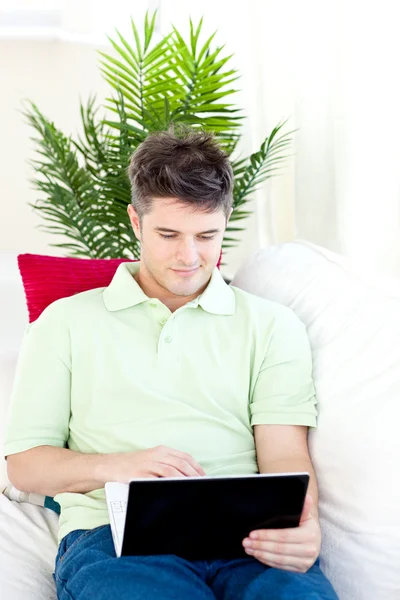 Charmig man sitter framför sin bärbara dator — Stockfoto