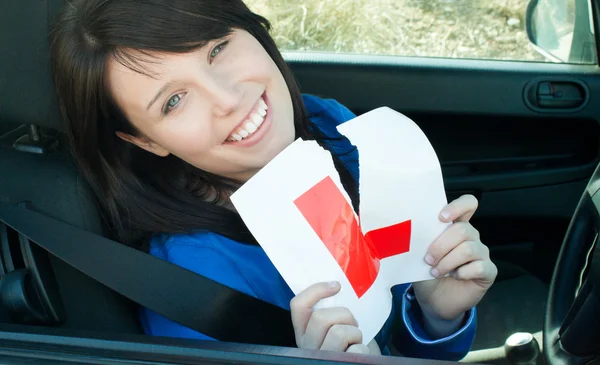 Χαρούμενος νεαρός γυναίκα οδηγός ξηλώνοντας το σημάδι της l — Φωτογραφία Αρχείου