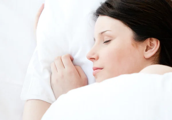 Mujer joven relajada acostada en una cama durmiendo —  Fotos de Stock