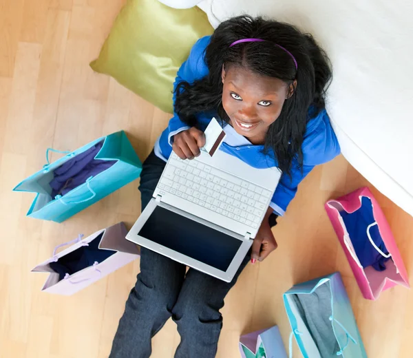 Jovem adolescente radiante sentado no chão com laptop e loja — Fotografia de Stock