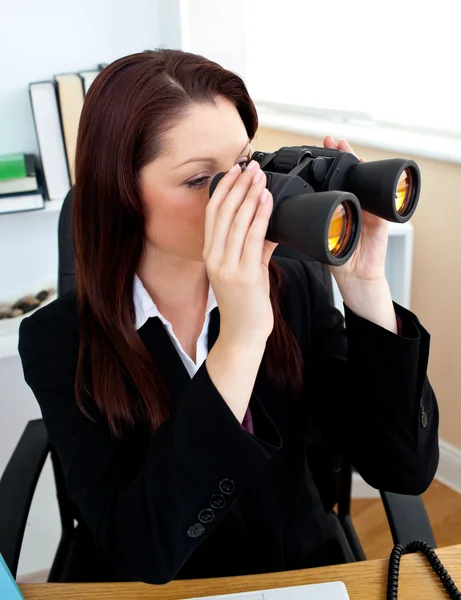 Konzentrierte Geschäftsfrau, die durch eine Spionagebrille blickt — Stockfoto