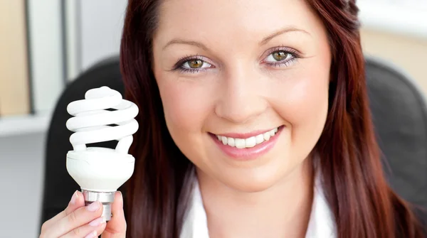 Красивая деловая женщина держит лампочку — стоковое фото