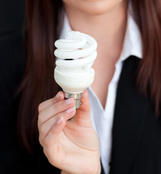 Primo piano di una giovane imprenditrice con in mano una lampadina — Foto Stock