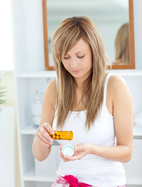 Seriös kvinna med piller i badrummet — Stockfoto