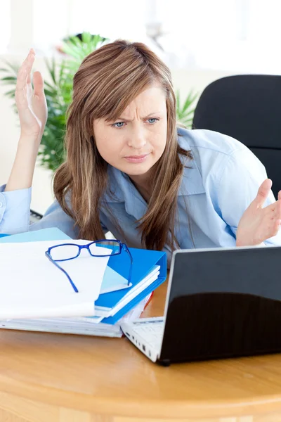 Раздражённая деловая женщина смотрит на свой ноутбук — стоковое фото