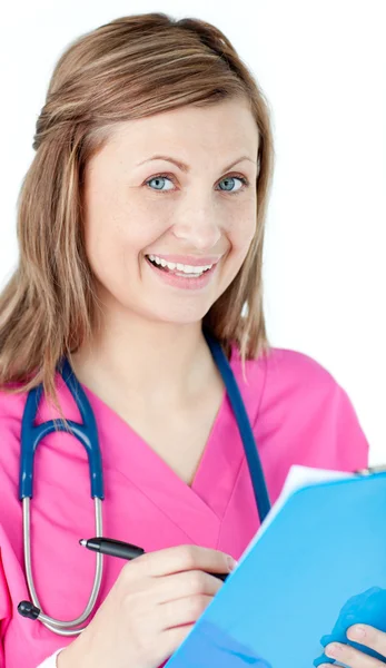 Lächelnde Ärztin schreibt auf ihren Notizblock — Stockfoto