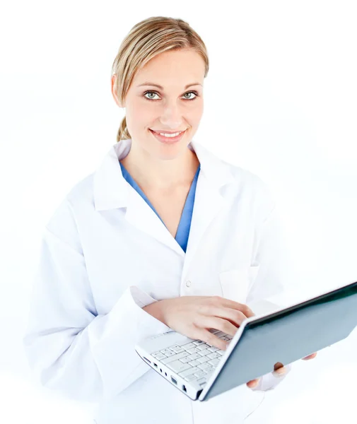 Bájos női orvos gazdaság egy laptop néz a kamerába — Stock Fotó