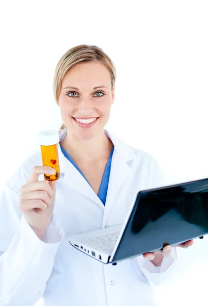 Sorrindo jovem médico segurando um laptop e pílulas — Fotografia de Stock