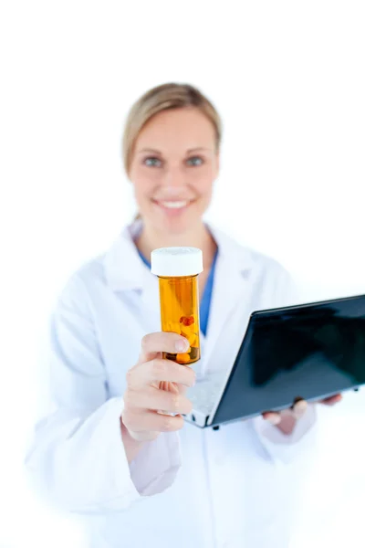 Charesmatic médico feminino segurando um laptop e pílulas — Fotografia de Stock
