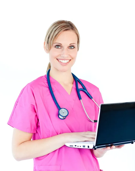 Enfermera encantada sosteniendo un portátil sonriendo a la cámara — Foto de Stock