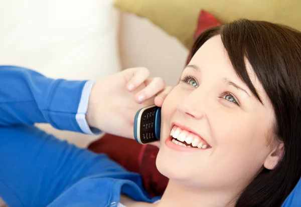 Adolescente alegre falando ao telefone deitado em um sofá — Fotografia de Stock