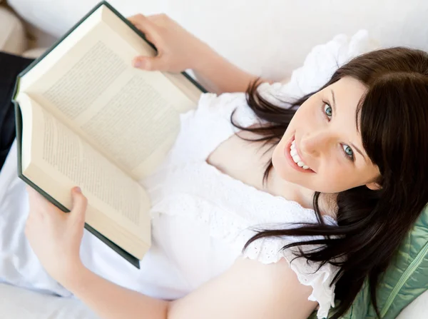 Adolescente brune lumineuse tenant un livre souriant à la caméra — Photo