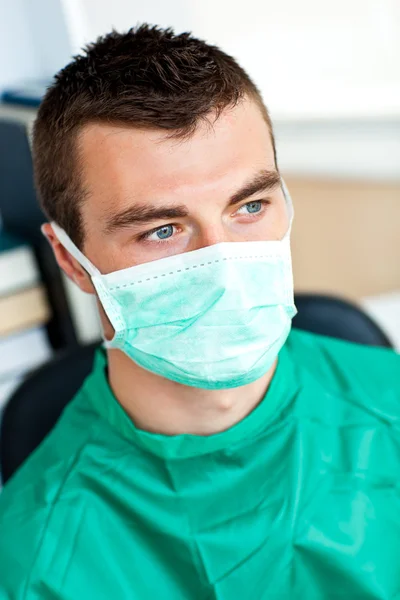Серьезный хирург-мужчина в маске и халате — стоковое фото