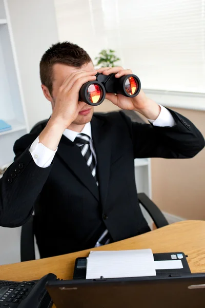 Skoncentrowany młody biznesmen patrząc przez binoluars — Zdjęcie stockowe