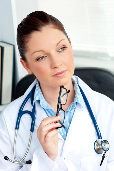 Nachdenkliche Ärztin sitzt in ihrem Büro — Stockfoto
