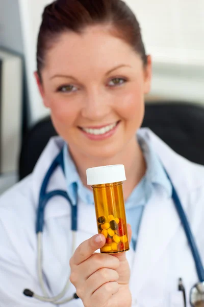 Zachwycony kobieta lekarz trzymając tabletki do aparatu — Zdjęcie stockowe