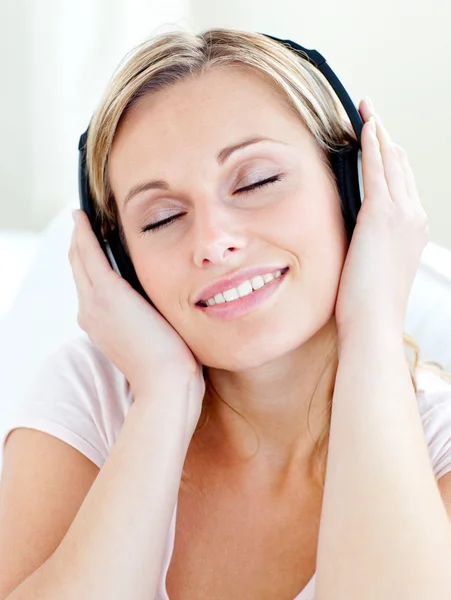 Mulher jovem radiante ouvir música usando fones de ouvido — Fotografia de Stock