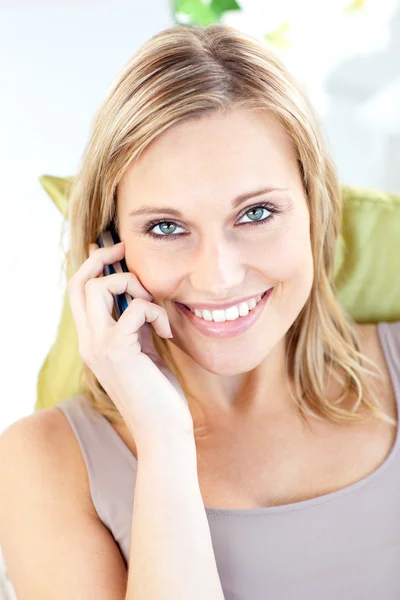 Красивая белая женщина разговаривает по телефону улыбаясь в камеру — стоковое фото
