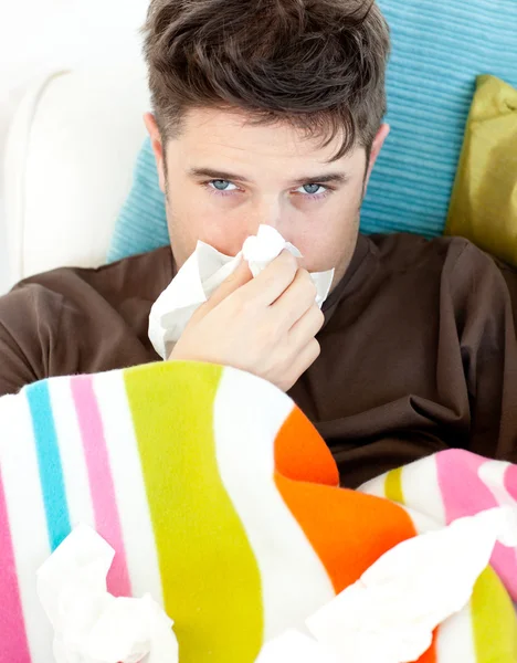 Joven enfermo con pañuelos en el sofá —  Fotos de Stock