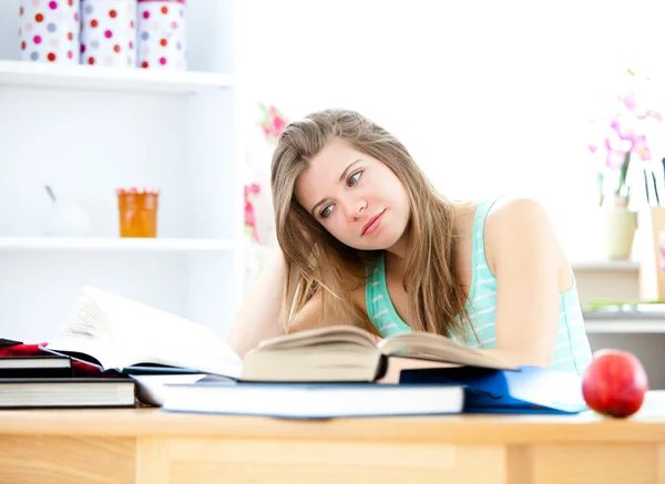 Jovem estressada estudando em sua cozinha — Fotografia de Stock