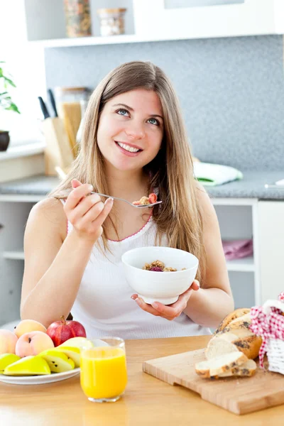 Glödande brunett kvinna äta spannmål med raspberrie i kit — Stockfoto