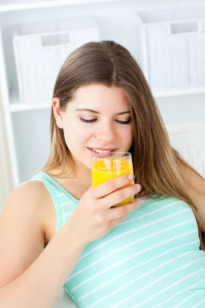 Белая молодая женщина пьет апельсиновый сок — стоковое фото