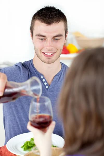 Çekici bir adam şarap içme kız arkadaşı ile yemek yerken — Stok fotoğraf
