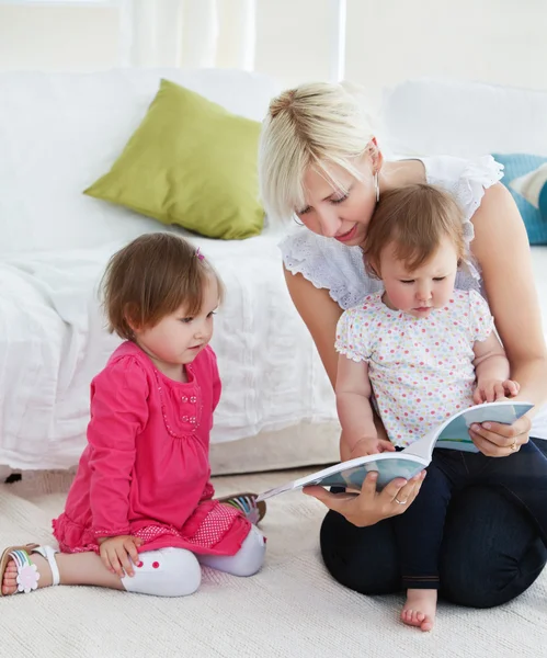 Liten familj läser en bok — Stockfoto