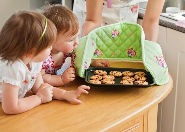 Leende kvinna bakning med döttrarna — Stockfoto