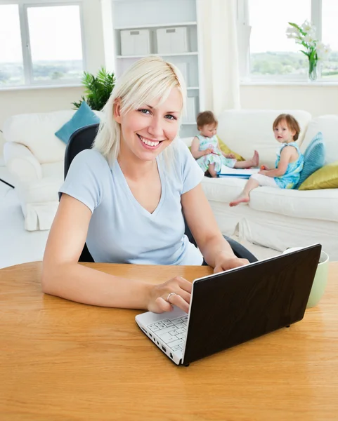 Blond moeder met behulp van laptop — Stockfoto