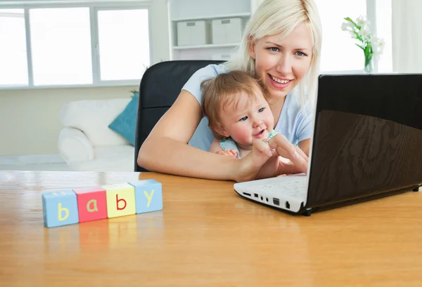 Enthusiastic daughter sitting in front of the laptop — Stock Photo, Image