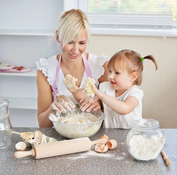 Simper 女性は彼女の娘と一緒にクッキーを焼く — ストック写真