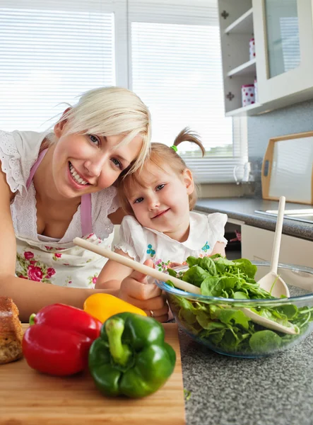 Usmívající se matka a dcera připravuje salát v kuchyni — Stock fotografie