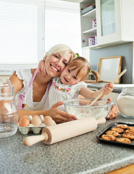 笑的女人与她的女儿烘烤饼干 — 图库照片