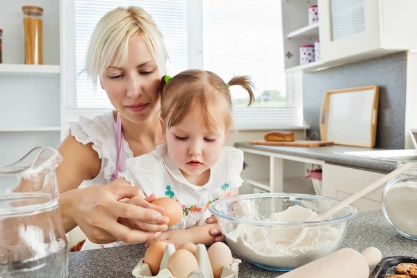Mujer enfocada horneando galletas con su hija — Foto de Stock