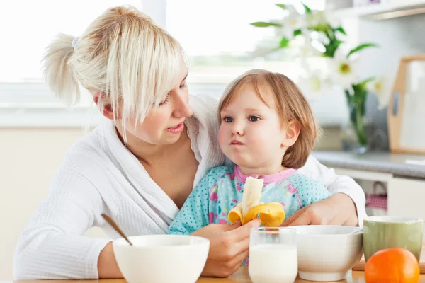 Mãe atraente tomando café da manhã com sua filha — Fotografia de Stock