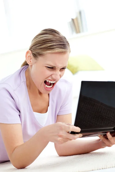 Wütende junge Frau schreit auf ihren Laptop — Stockfoto