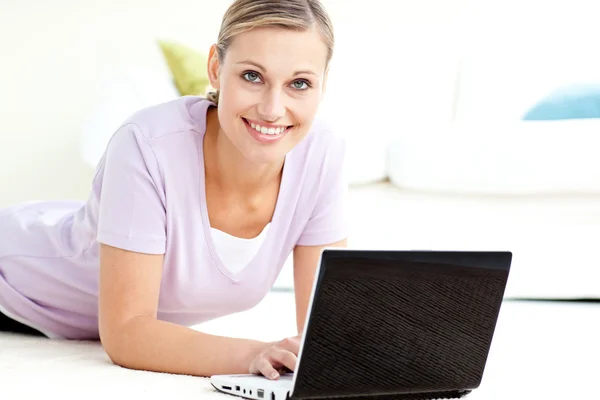 Pozitivní žena pomocí její laptop na podlaze — Stock fotografie