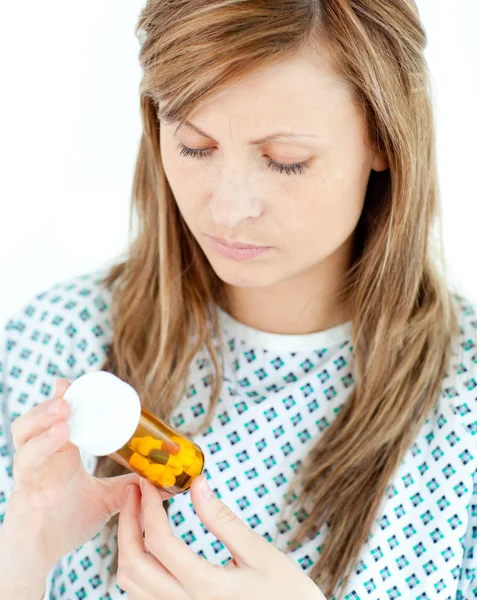 Koncentrerad kvinnliga patienten tittar på hennes piller — Stockfoto