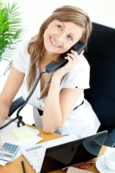 Pewna siebie kobieta rozmawia telefon siedzi przy biurku — Zdjęcie stockowe