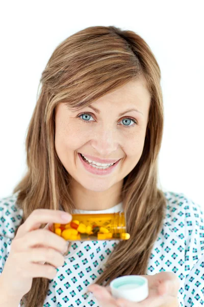 Улыбающаяся молодая женщина принимает таблетки — стоковое фото