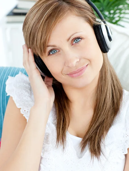 Ritratto di una donna deliziata ascoltare musica con le cuffie — Foto Stock