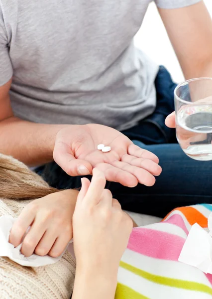 Nahaufnahme eines jungen Mannes, der seiner krankhaften Freundin Tabletten verabreicht — Stockfoto